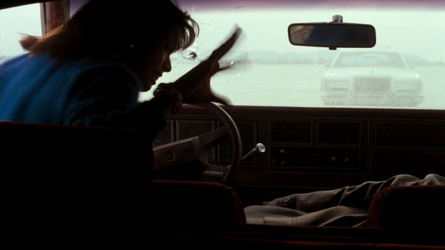 Wide shot frame from Lethal Weapon — sitting, dialogue, street