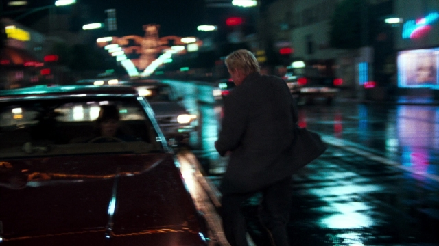 Wide shot frame from Lethal Weapon — walking, street, car