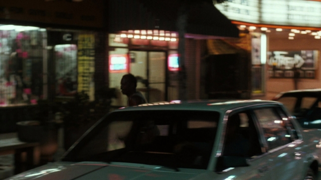 Wide shot frame from Lethal Weapon — walking, street, car