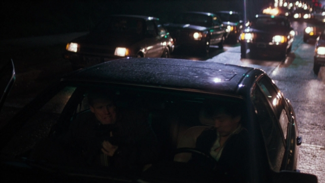 Wide shot frame from Lethal Weapon — sitting, street, car