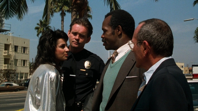 Wide shot frame from Lethal Weapon — standing, dialogue, street