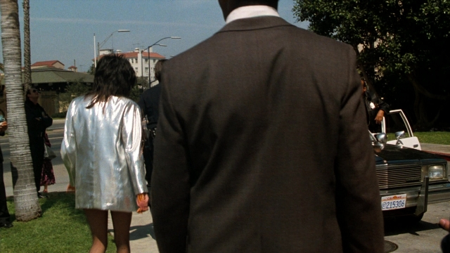 Wide shot frame from Lethal Weapon — walking, street, car