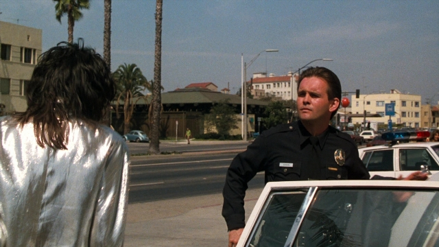 Wide shot frame from Lethal Weapon — standing, dialogue, street