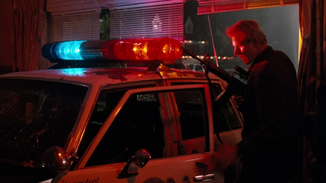 Wide shot frame from Lethal Weapon — standing, street, car