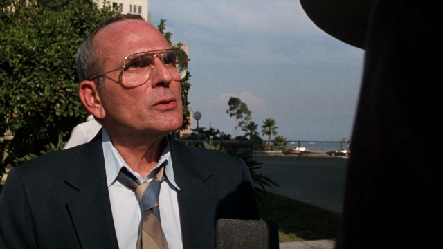 Medium shot frame from Lethal Weapon — standing, suit, tie
