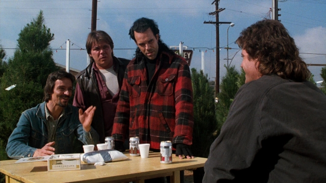 Wide shot frame from Lethal Weapon — sitting, table, dialogue