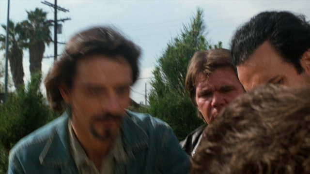 Medium shot frame from Lethal Weapon — standing, beard, mustache