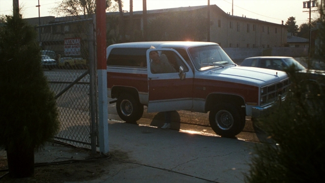 Wide shot frame from Lethal Weapon — sitting, car, wheel