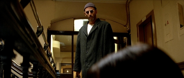 Wide shot frame from Léon — standing, door, coat