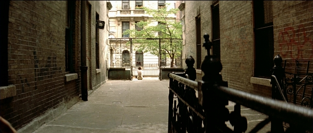 Wide shot frame from Léon — walking, street, house