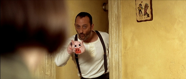 Wide shot frame from Léon — standing, coat, hand