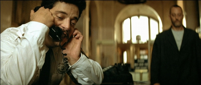 Wide shot frame from Léon — standing, room, dialogue