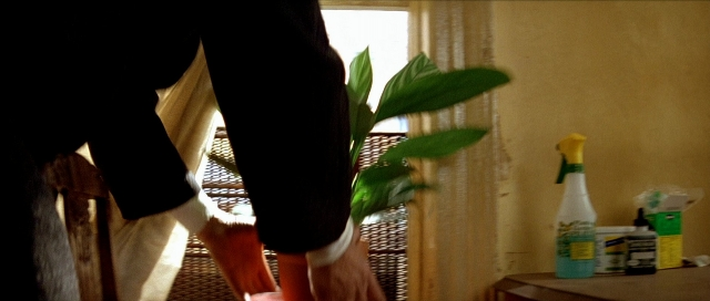 Wide shot frame from Léon — standing, room, table