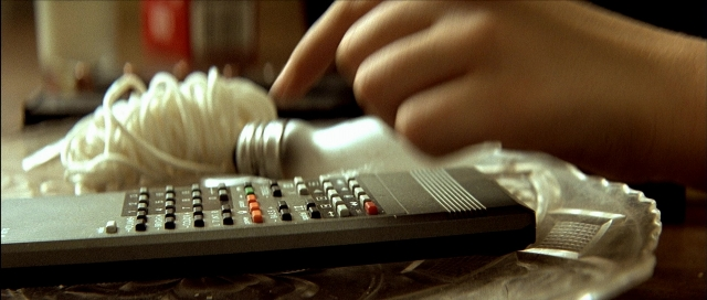 Wide shot frame from Léon — table, hand, person