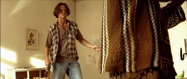 Wide shot frame from Léon — standing, room, table