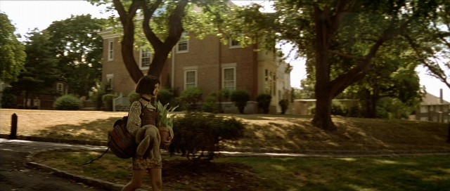 Wide shot frame from Léon — walking, street, house