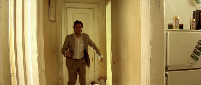 Wide shot frame from Léon — walking, door, hand