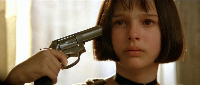 Close-up frame from Léon — room, hand, gun