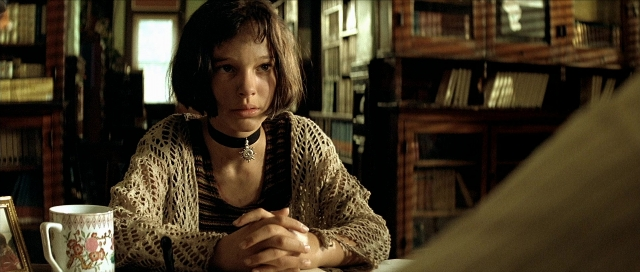 Wide shot frame from Léon — sitting, table, hair