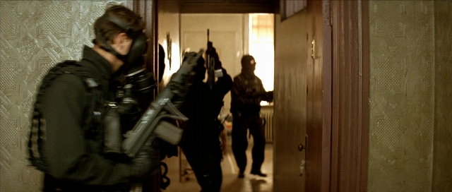 Wide shot frame from Léon — standing, door, hand