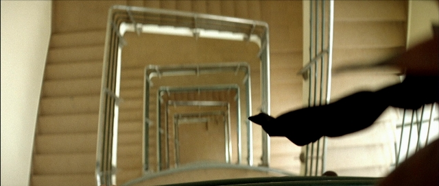 Wide shot frame from Léon — room, hand, cat