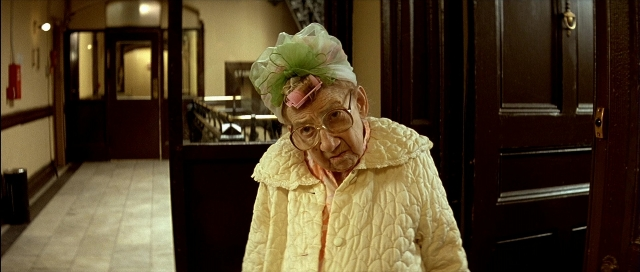 Frame from Léon — standing, door, hat