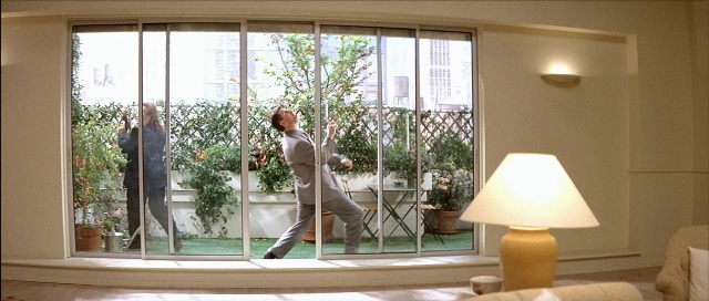 Wide shot frame from Léon — standing, room, suit