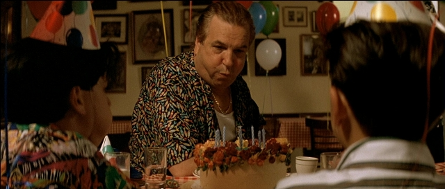 Wide shot frame from Léon — sitting, table, dialogue