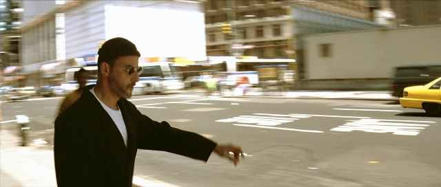 Frame from Léon — standing, street, car