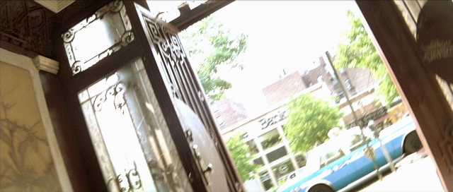 Wide shot frame from Léon — room, door, street