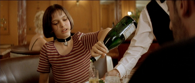 Wide shot frame from Léon — sitting, standing, table
