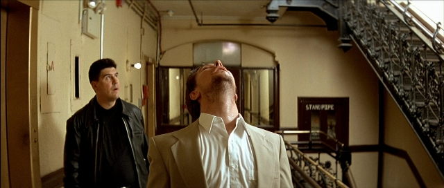 Wide shot frame from Léon — standing, suit, face