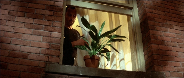 Wide shot frame from Léon — standing, hand, house