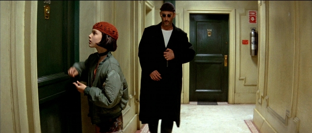 Wide shot frame from Léon — standing, door, hat