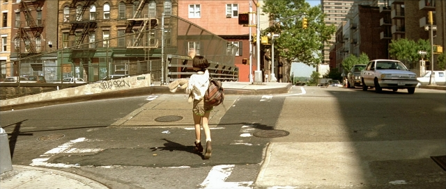 Wide shot frame from Léon — walking, street, car