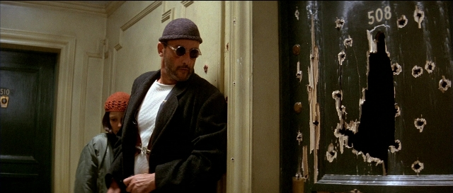 Wide shot frame from Léon — standing, door, coat