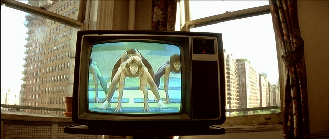 Wide shot frame from Léon — sitting, monkey, television