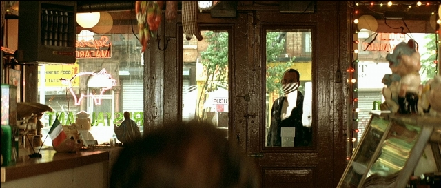 Wide shot frame from Léon — sitting, standing, door
