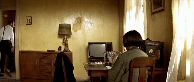 Wide shot frame from Léon — sitting, desk, standing