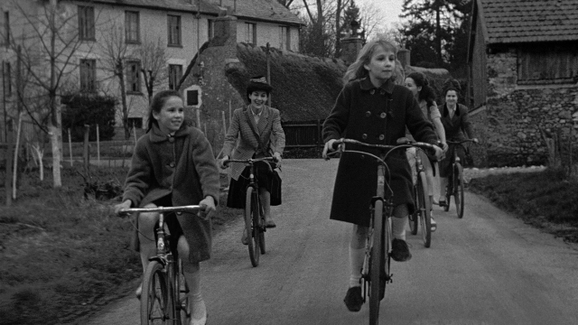 Wide shot frame from Léon Morin, prêtre — street, bicycle, person