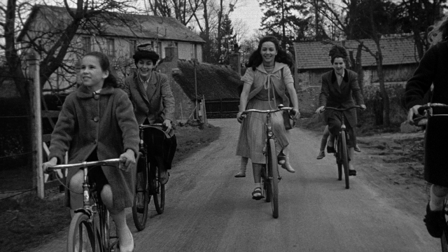 Wide shot frame from Léon Morin, prêtre — street, bicycle, person