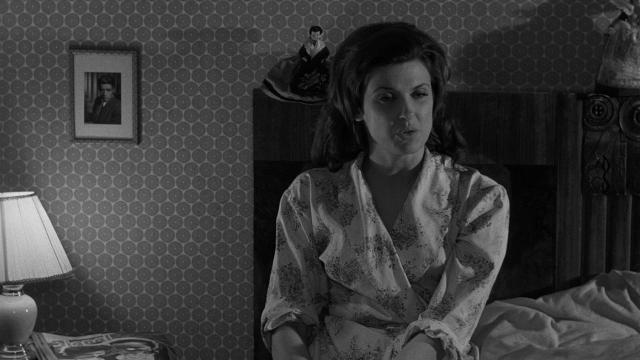 Wide shot frame from Léon Morin, prêtre — sitting, bed, face