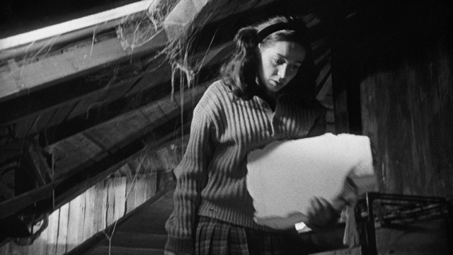 Wide shot frame from Léon Morin, prêtre — standing, face, hair
