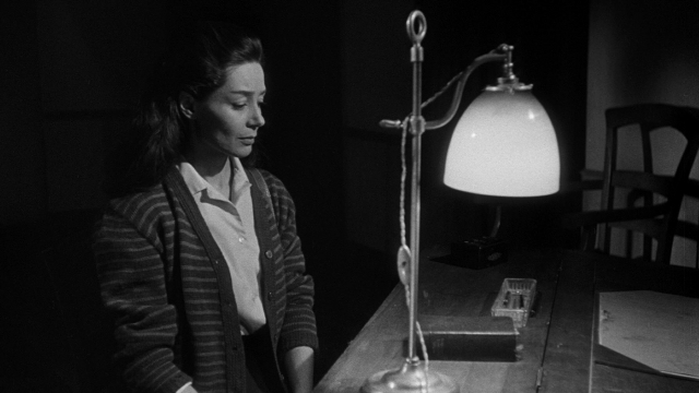 Wide shot frame from Léon Morin, prêtre — sitting, room, chair