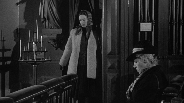 Wide shot frame from Léon Morin, prêtre — sitting, standing, room