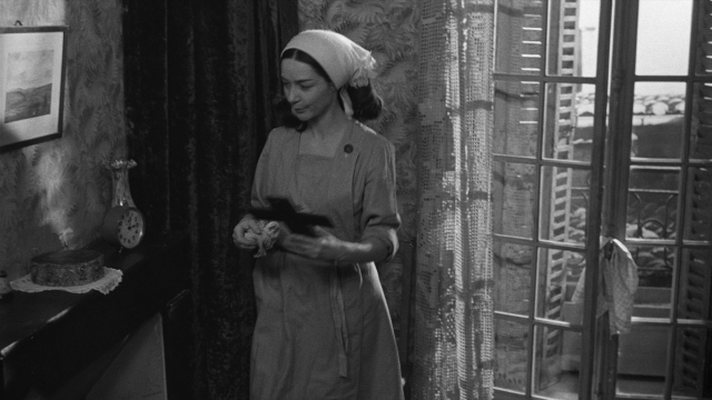 Wide shot frame from Léon Morin, prêtre — book, standing, room