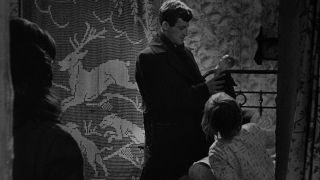 Wide shot frame from Léon Morin, prêtre — sitting, standing, room