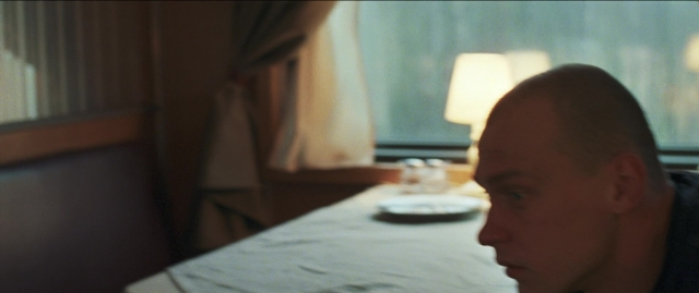 Frame from Compartiment n°6 — sitting, plate, room