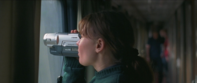 Wide shot frame from Compartiment n°6 — standing, hand, face