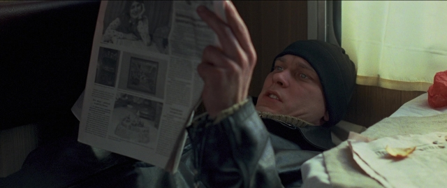 Wide shot frame from Compartiment n°6 — bed, face, newspaper